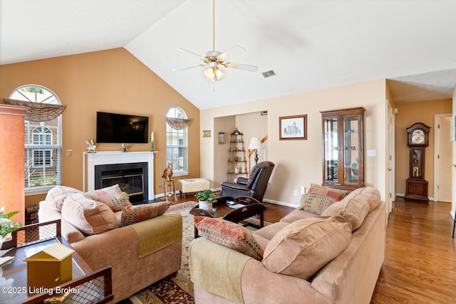living room with visible vents, ceiling fan, wood finished floors, a healthy amount of sunlight, and a glass covered fireplace