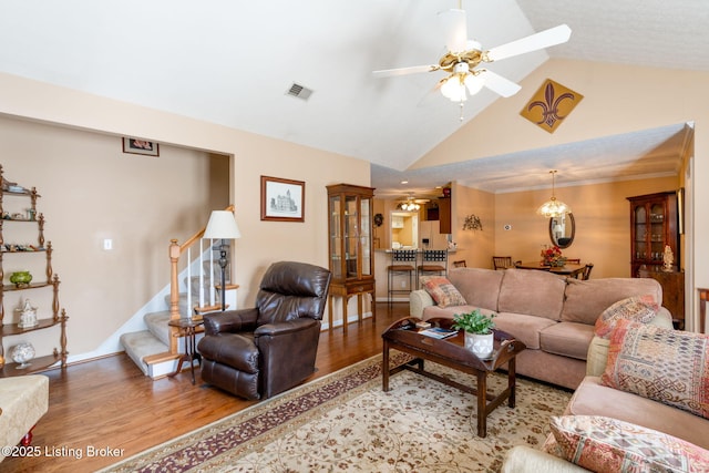 living room with stairway, light wood-type flooring, high vaulted ceiling, visible vents, and ceiling fan