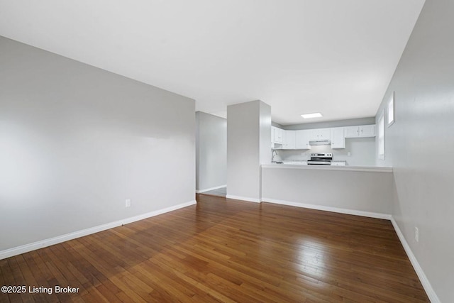 3217 Wellingmoor Ave, Louisville, KY 40218 - unfurnished living room featuring baseboards and wood-type flooring