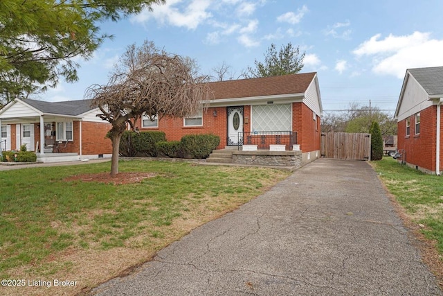 3217 Wellingmoor Ave, Louisville, KY 40218 - view of front of home with aphalt driveway, brick siding, a front yard, and fence
