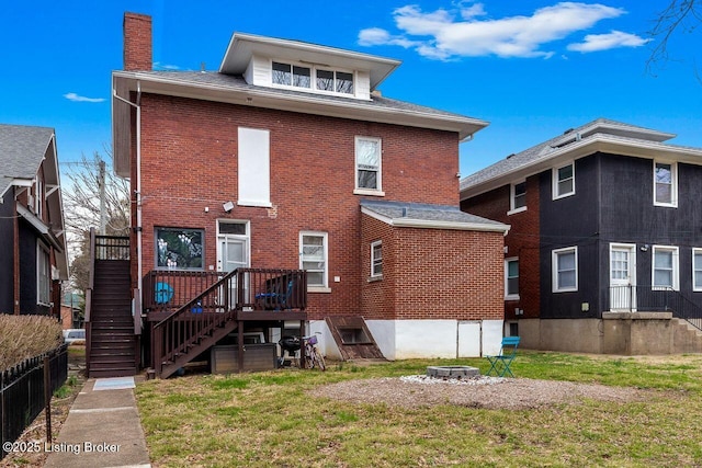 rear view of house featuring brick siding, a chimney, and a yard