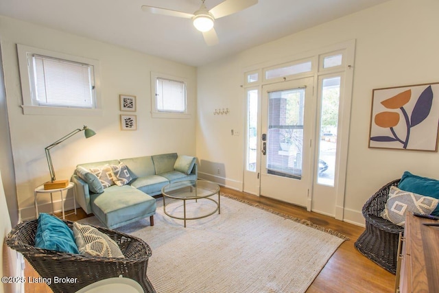 living room featuring a ceiling fan, wood finished floors, and baseboards