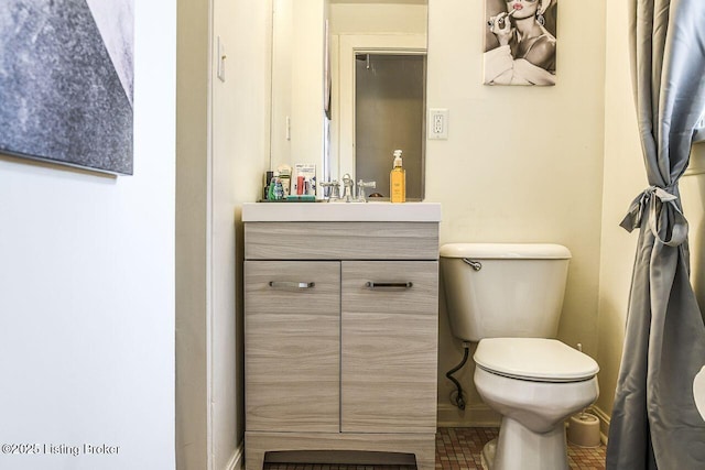 bathroom with vanity, toilet, and baseboards