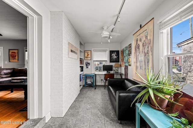 tiled office featuring a ceiling fan, track lighting, and a healthy amount of sunlight