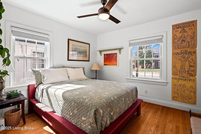 bedroom with a ceiling fan, baseboards, and wood finished floors