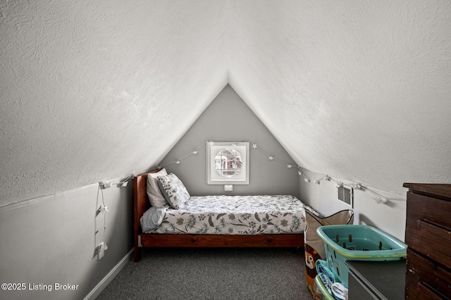 unfurnished bedroom featuring baseboards, lofted ceiling, carpet floors, and a textured ceiling