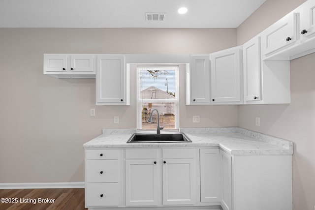 2064 Emmet Ave, Louisville, KY 40217 - kitchen featuring a sink, visible vents, light countertops, and white cabinetry