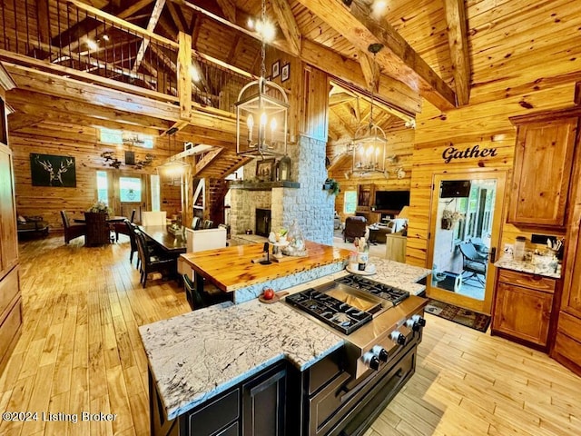 kitchen featuring light wood-style floors, open floor plan, a notable chandelier, and wooden walls