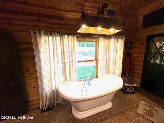 full bath with a freestanding bath, wooden walls, and tile patterned floors