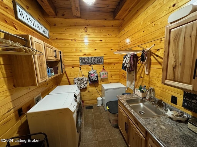 laundry room featuring independent washer and dryer, wood ceiling, wood walls, a sink, and cabinet space