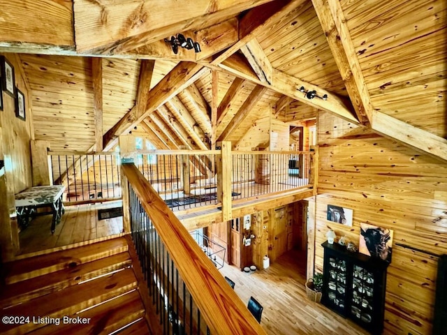 interior space with an upstairs landing, hardwood / wood-style flooring, wooden ceiling, and lofted ceiling with beams