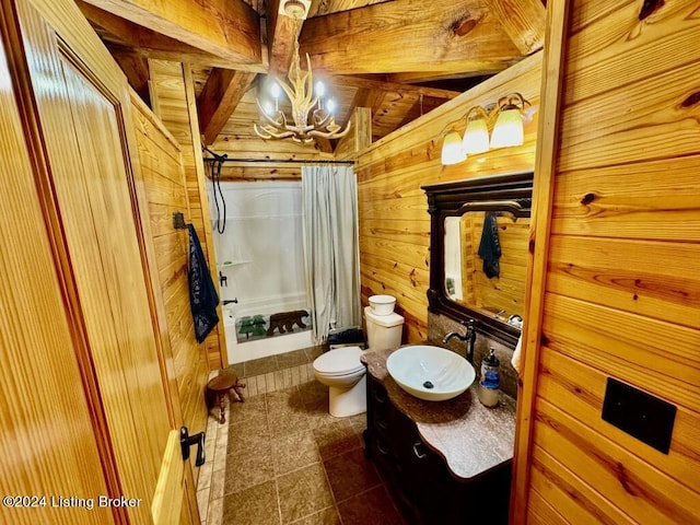 full bath featuring vanity, an inviting chandelier, wooden walls, toilet, and shower / bath combo with shower curtain