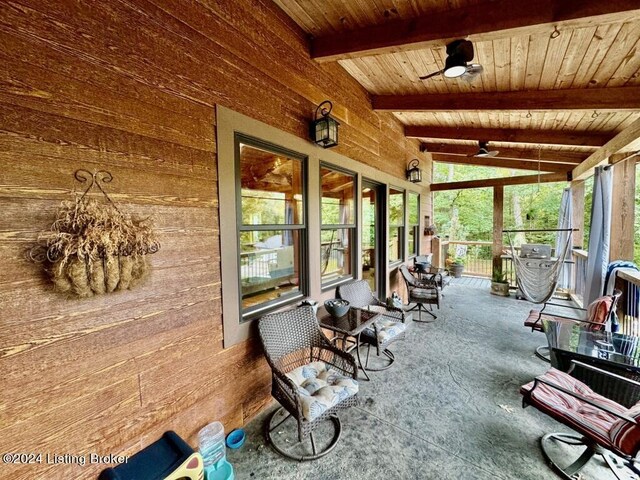 sunroom / solarium featuring wood walls, a wealth of natural light, lofted ceiling with beams, and wood ceiling