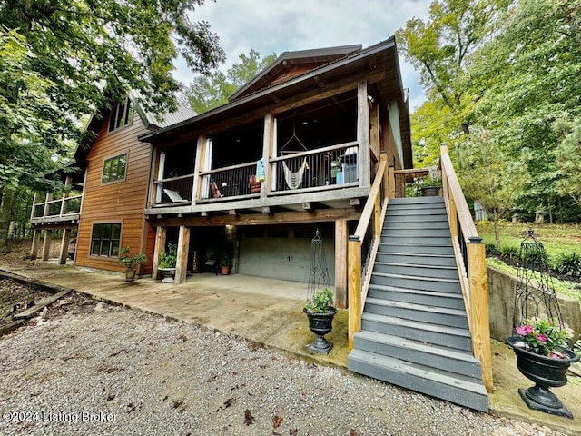 back of property featuring a patio and stairway