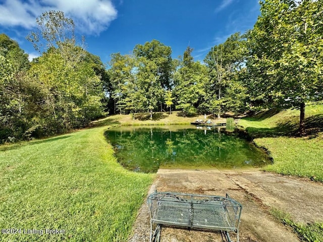 surrounding community featuring a water view and a lawn