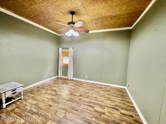 spare room featuring baseboards, ornamental molding, a ceiling fan, wood ceiling, and wood finished floors