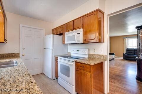 3307 Leith Ln Apt 3, Louisville, KY 40218 - kitchen with a sink, white appliances, brown cabinets, and light stone countertops