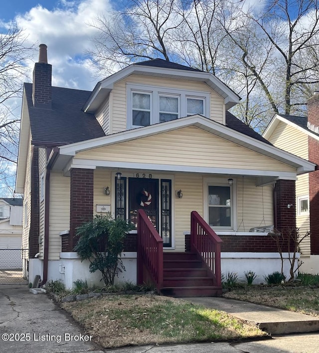 628 Harrison Ave, Louisville, KY 40217 - bungalow-style home featuring a chimney, a porch, and brick siding
