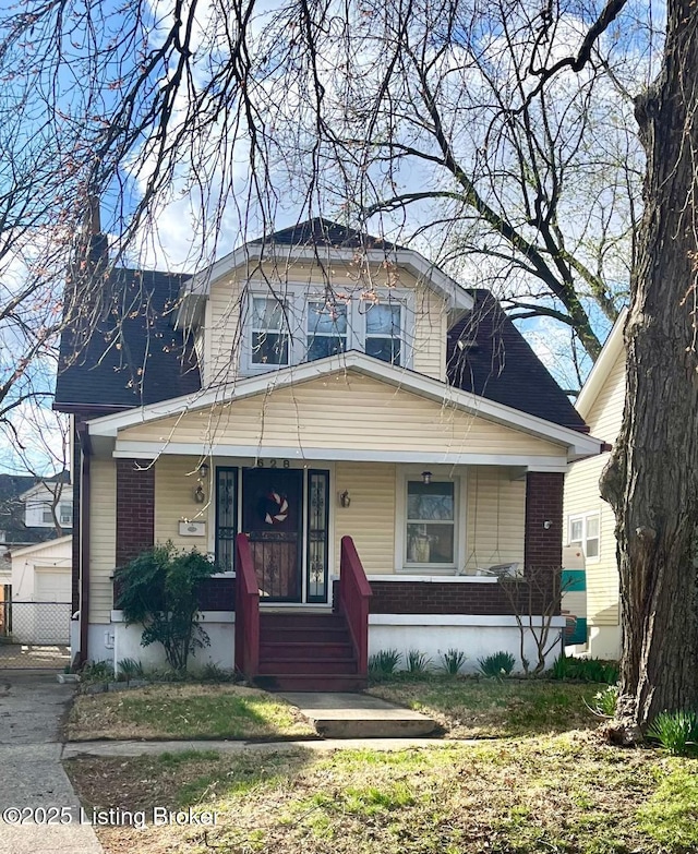 628 Harrison Ave, Louisville, KY 40217 - view of front facade featuring a porch, brick siding, and a garage