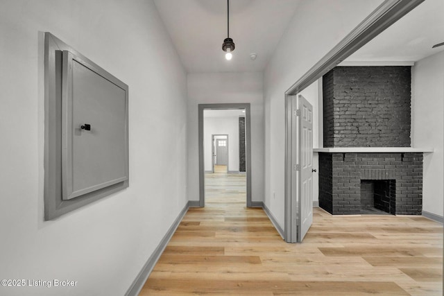 corridor with baseboards and light wood-style floors