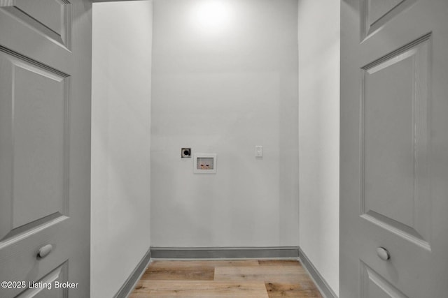 clothes washing area with washer hookup, hookup for an electric dryer, light wood-style flooring, laundry area, and baseboards