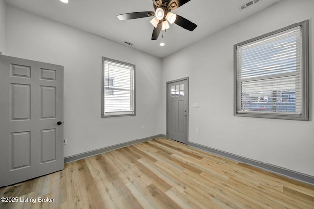 entrance foyer featuring baseboards, visible vents, light wood-type flooring, and a ceiling fan