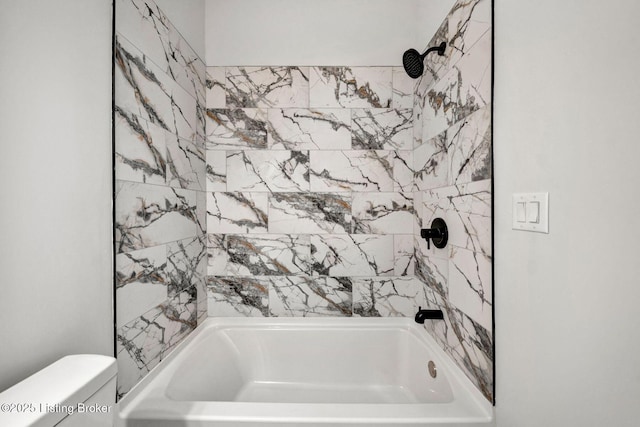 bathroom with bathtub / shower combination and toilet