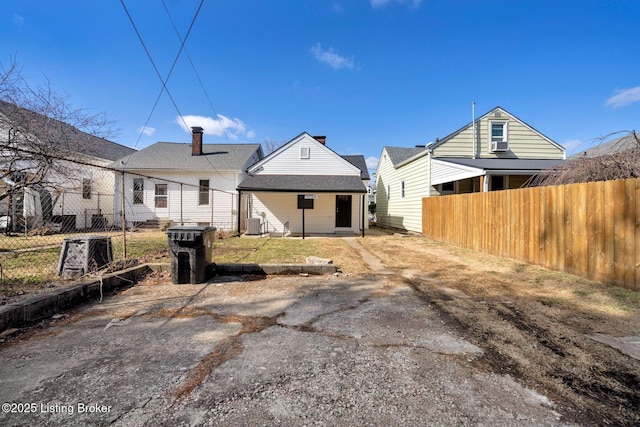 rear view of house featuring fence
