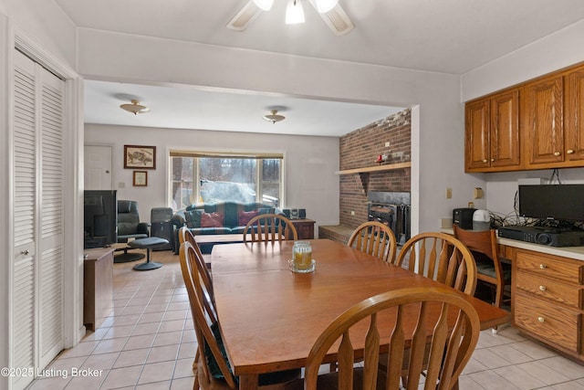 1147 Poplar Grove Rd, Buffalo, KY 42716 - dining space with light tile patterned floors, a fireplace, and a ceiling fan