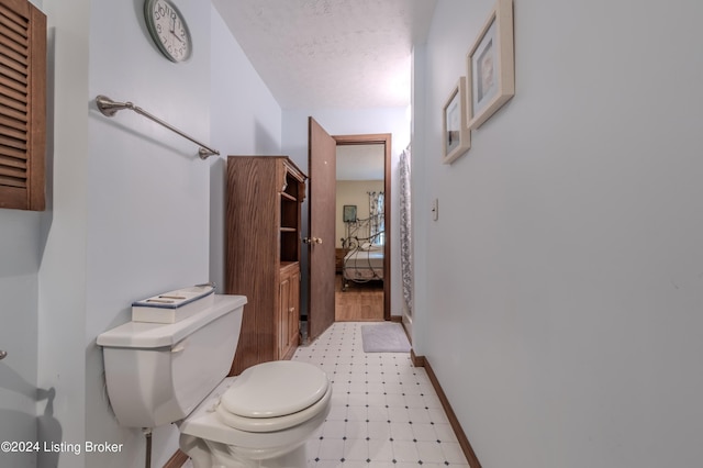110 Nathan Rd, Falls Of Rough, KY 40119 - bathroom with tile patterned floors, toilet, baseboards, and a textured ceiling