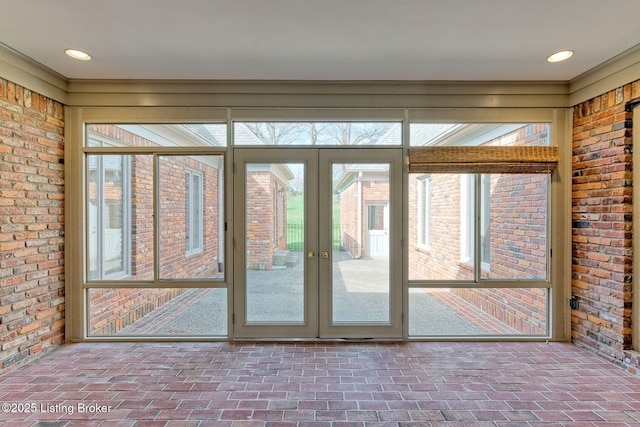 doorway to outside featuring brick wall and brick floor