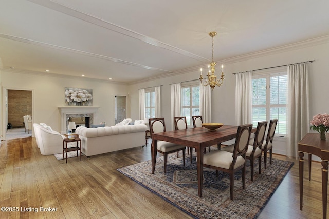 dining space featuring hardwood / wood-style flooring, ornamental molding, and an inviting chandelier