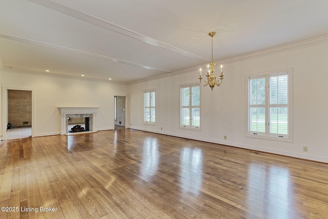 unfurnished living room featuring a high end fireplace, baseboards, hardwood / wood-style flooring, and an inviting chandelier