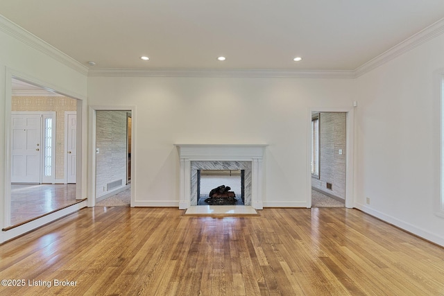unfurnished living room with baseboards, ornamental molding, wood finished floors, and visible vents