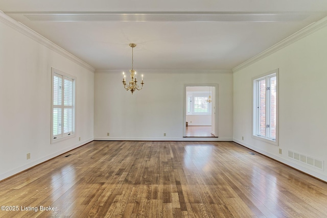 unfurnished room featuring hardwood / wood-style floors, visible vents, an inviting chandelier, and a healthy amount of sunlight