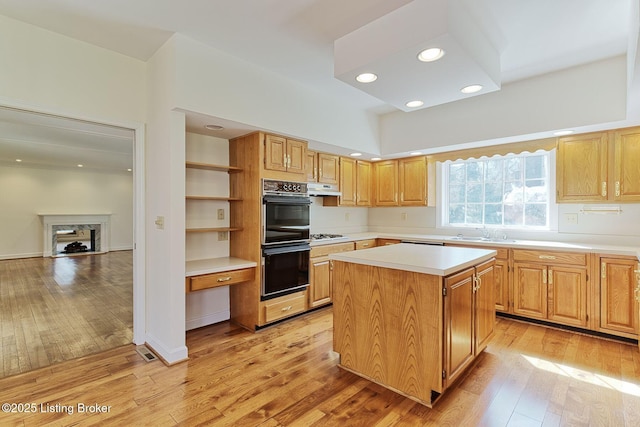 kitchen with dobule oven black, open shelves, light wood-type flooring, light countertops, and under cabinet range hood