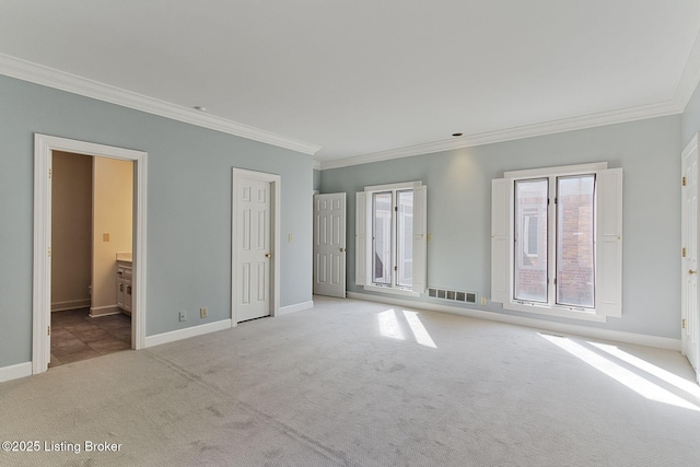 interior space with carpet, visible vents, crown molding, and baseboards