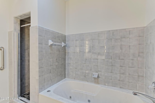 full bath featuring a shower stall and a tub with jets
