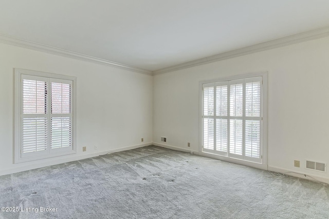 carpeted empty room featuring visible vents, baseboards, and ornamental molding