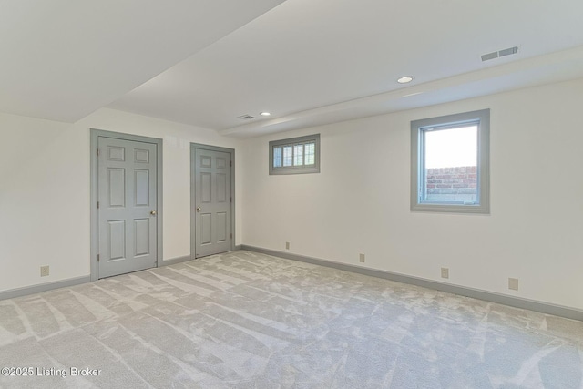 below grade area with light colored carpet, baseboards, visible vents, and recessed lighting