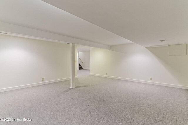 finished below grade area with baseboards, stairs, and carpet flooring
