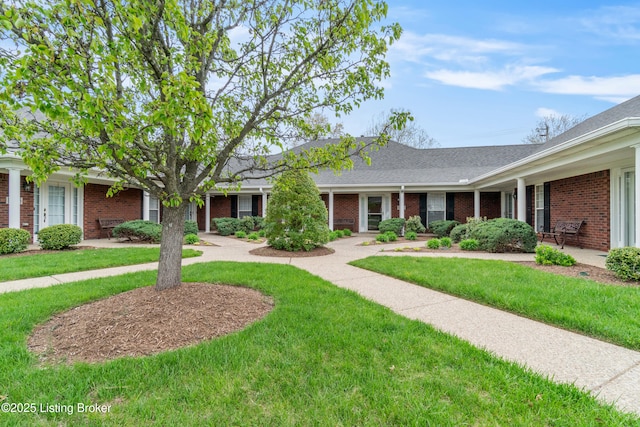 single story home featuring a front yard and brick siding