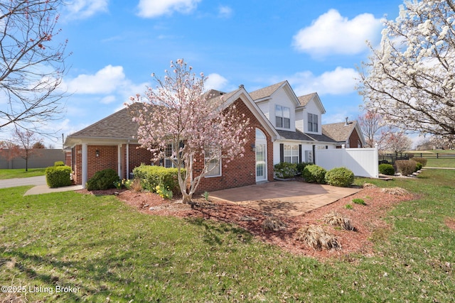 135C Michelle Dr, Shepherdsville, KY 40165 - view of front facade with brick siding, fence, a patio, and a front lawn