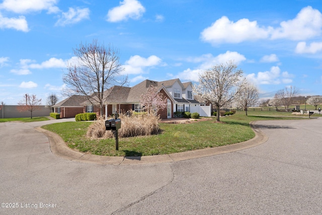135C Michelle Dr, Shepherdsville, KY 40165 - view of front facade with a front yard, brick siding, fence, concrete driveway, and an attached garage