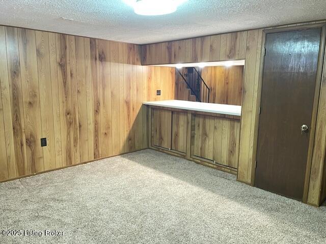 3509 Bardstown Rd, Elizabethtown, KY 42701 - unfurnished room with stairway, wood walls, carpet, and a textured ceiling