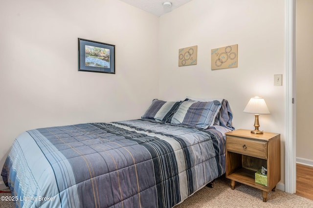 bedroom with light carpet and baseboards