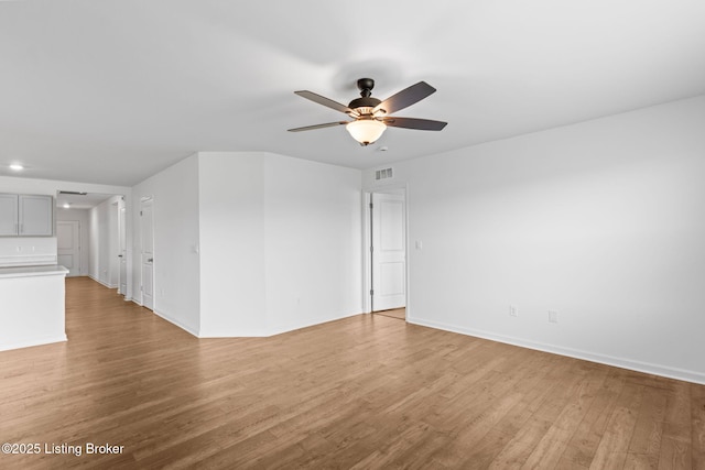 243 Zelcova Dr, Eminence, KY 40019 - unfurnished living room with visible vents, baseboards, a ceiling fan, and light wood-style floors