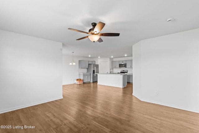 243 Zelcova Dr, Eminence, KY 40019 - unfurnished living room featuring baseboards, recessed lighting, a ceiling fan, a sink, and wood finished floors