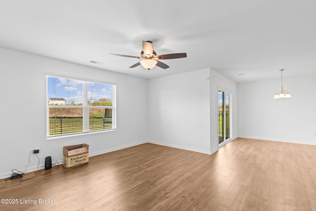 243 Zelcova Dr, Eminence, KY 40019 - spare room with visible vents, light wood-type flooring, baseboards, and ceiling fan with notable chandelier