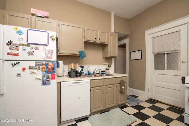 kitchen with light countertops, a sink, light floors, baseboards, and white appliances